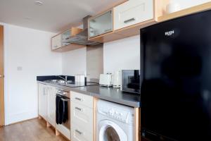 eine Küche mit Waschmaschine und Trockner in der Unterkunft The 'Tailors' Apartment in Leicester