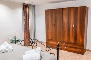 ein Schlafzimmer mit einem großen Holzschrank neben einem Bett in der Unterkunft Daria’s home apartament in Palermo
