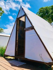 a triangular tent with a door on a wooden deck at Primitivo glamping buzios in Búzios