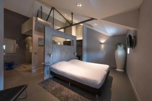 ein Schlafzimmer mit einem weißen Bett in einem Zimmer in der Unterkunft Boutique Hotel Cordial in Oss