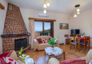 uma sala de estar com uma lareira de tijolos e uma mesa em Villa Dimosthenis em Stalos