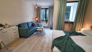 sypialnia z łóżkiem i niebieską kanapą w obiekcie Borovets Holiday Homes w Borowcu