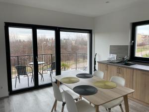 een keuken met een tafel en stoelen en een balkon bij Kertvárosi nyugalom in Balatonfüred