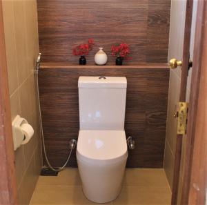 a bathroom with a toilet with two vases on the wall at The Spice House Mirissa in Mirissa
