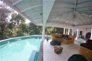 a swimming pool with a couch and a table at The Spice House Mirissa in Mirissa