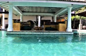 a swimming pool with a gazebo and water at The Spice House Mirissa in Mirissa