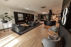 a living room with couches and chairs and a television at Gr8 Hotel Bodegraven in Bodegraven