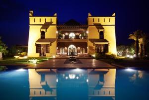 a large house with a pool in front of it at night at Villa Malika Silvana in Marrakech