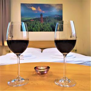 due bicchieri di vino rosso seduti su un tavolo di Penzion Adéla a Rožnov pod Radhoštěm