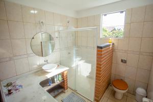 a bathroom with a shower and a sink and a toilet at Caiowa Floripa guesthouse in Florianópolis