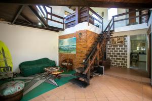 a living room with a green couch and a staircase at Caiowa Floripa guesthouse in Florianópolis