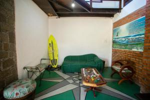 a room with a couch and a surfboard on the wall at Caiowa Floripa guesthouse in Florianópolis