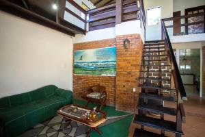 a living room with a green couch and a staircase at Caiowa Floripa guesthouse in Florianópolis