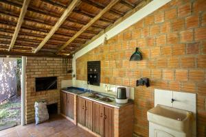 a kitchen with a sink and a brick wall at Caiowa Floripa guesthouse in Florianópolis +37 photos