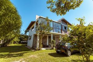 a house with a car parked in front of it at Caiowa Floripa guesthouse in Florianópolis