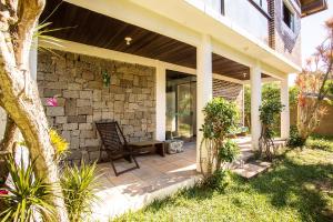 a house with a chair on a patio at Caiowa Floripa guesthouse in Florianópolis