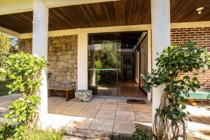 a glass door of a house with a patio at Caiowa Floripa guesthouse in Florianópolis