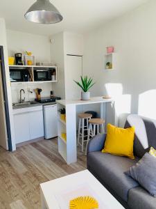 a living room with a couch and a kitchen at Super Appart ! Terrasse, Clim, Parking, 2min Plage. in La Grande-Motte