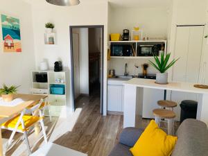 a kitchen and living room with a couch and a table at Super Appart ! Terrasse, Clim, Parking, 2min Plage. in La Grande-Motte