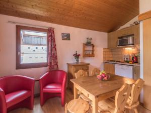 een keuken met een houten tafel en rode stoelen en een tafel en een tafel bij Appartement Chamonix-Mont-Blanc, 2 pièces, 4 personnes - FR-1-517-26 in Chamonix-Mont-Blanc
