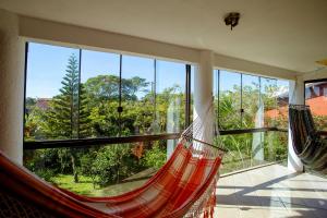 a hammock in a room with a large window at Caiowa Floripa guesthouse in Florianópolis