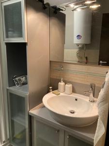 a bathroom with a white sink and a mirror at Studio Detelina Residence in Bansko