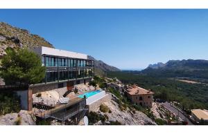 a building on top of a mountain with a swimming pool at Casa Liebre in Pollença