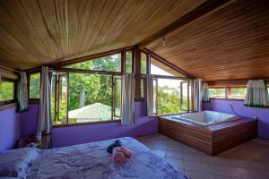 a bedroom with a bed and a bath tub at Caiowa Floripa guesthouse in Florianópolis