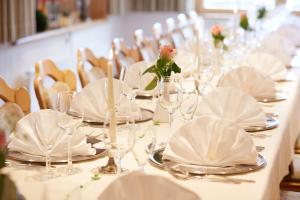 a table with white plates and wine glasses on it at Wander- & Wellnesshotel Nägele in Höchenschwand