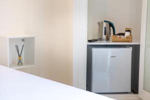 Cette chambre comprend un petit réfrigérateur et un comptoir. dans l'établissement Posada Boutique El Gallo Morón, à Morón de la Frontera