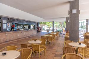 an empty restaurant with tables and chairs at Hotel Club Cala Romani in Calas de Mallorca