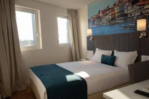 a bedroom with a bed and a window at Hotel Porto Interface Trindade By Kavia in Porto
