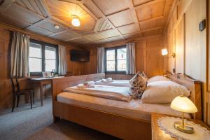 a bedroom with a large bed with a wooden ceiling at D`Alpenapartments Bezau in Bezau