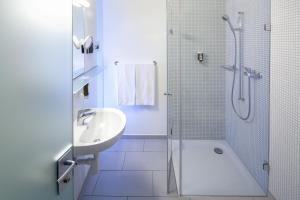 a bathroom with a shower, sink, and toilet at Hotel Balade in Basel