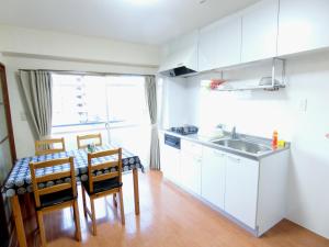 a kitchen with a table and chairs and a sink at Simple Stay Beppu in Beppu