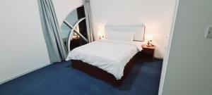 1 dormitorio con cama blanca y espejo en Havana Holiday Homes in Al Garhoud, en Dubái
