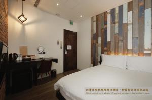 una camera d'albergo con letto, scrivania di Journey Hostel a Tainan