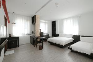 um quarto com 2 camas e uma secretária com uma mesa em Journey Hostel em Tainan