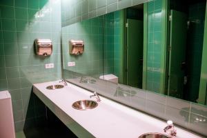 łazienka z 2 umywalkami i dużym lustrem w obiekcie AMISTAT Island Hostel Ibiza - ALBERGUE JUVENIL w mieście San Antonio