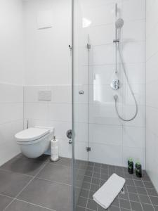 a white bathroom with a shower and a toilet at limehome Gütersloh Eickhoffstraße in Gütersloh