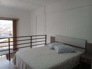 1 dormitorio con 1 cama y balcón en Loft torres praia da Cal, en Torres