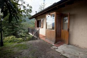 a house with a wooden door and a balcony at La Caseta del bosc de Sort in Sort