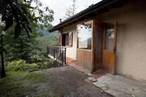 una casa con porta in legno e balcone di La Caseta del bosc de Sort a Sort