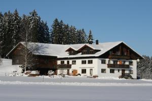 a house in the snow with snow covered trees at Haus Allgäu Ruh in Görisried