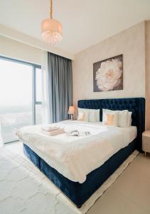 a large bed in a bedroom with a large window at Nasma Luxury Stays - Elegant Condo With City Views And Dubai Skyline in Dubai +85 photos