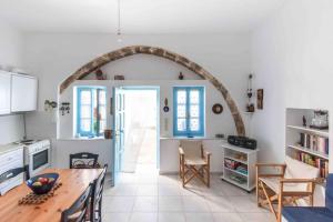 eine Küche mit einem Torbogen, einem Tisch und Stühlen in der Unterkunft Traditional Two Story House in Galanado Naxos in Galanádhon