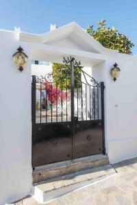 ein schwarzes Tor auf einem weißen Gebäude mit in der Unterkunft Traditional Two Story House in Galanado Naxos in Galanádhon