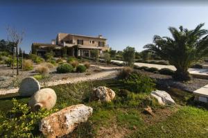 een huis met rotsen voor een tuin bij Finca El Sueno in Santanyi