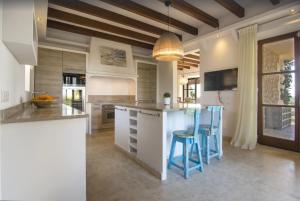 a kitchen with a island with blue stools at Finca El Sueno in Santanyi