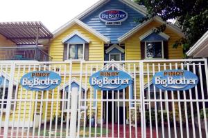 une maison jaune avec une clôture devant elle dans l'établissement Huge A2J Executive Luxury 1BR Suite Near ABS CBN, GMA, à Manille